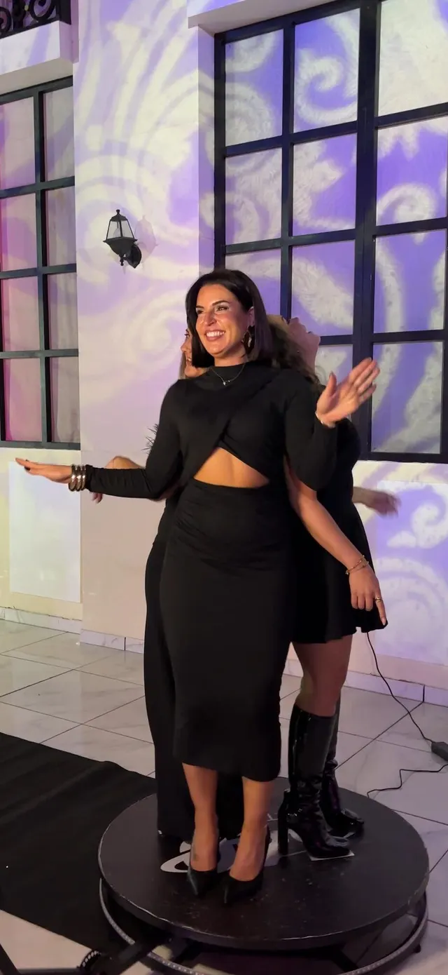Une invitée pose sur la plateforme du videobooth 360° pendant que le bras de la caméra tourne autour d'elle